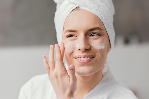 Free Photo woman using a white face cream