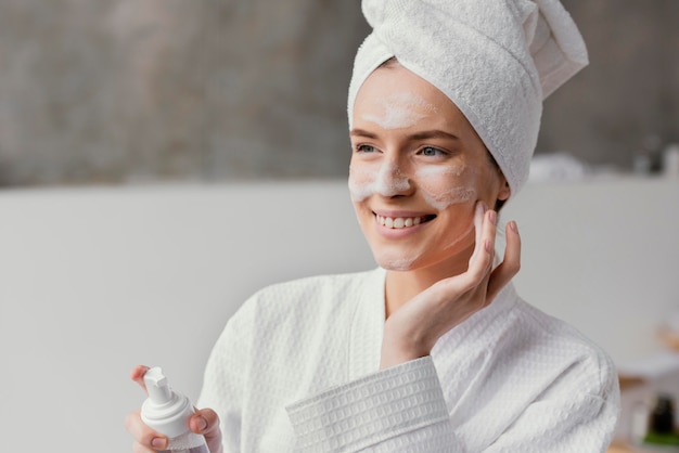 Free photo woman using a white face cream