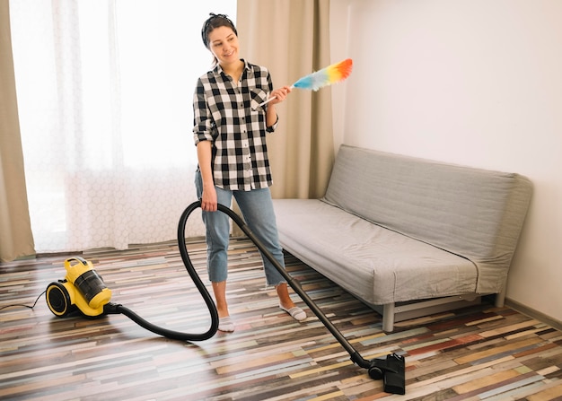 Free photo woman vacuuming in living room