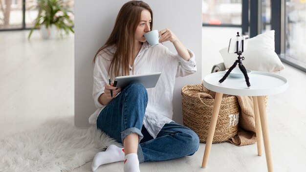 Woman vlogging with her phone indoors