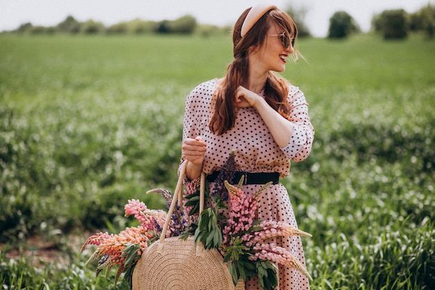 Woman walking in a field with lupinuses