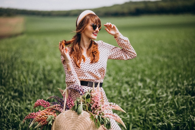 Woman walking in a field with lupinuses