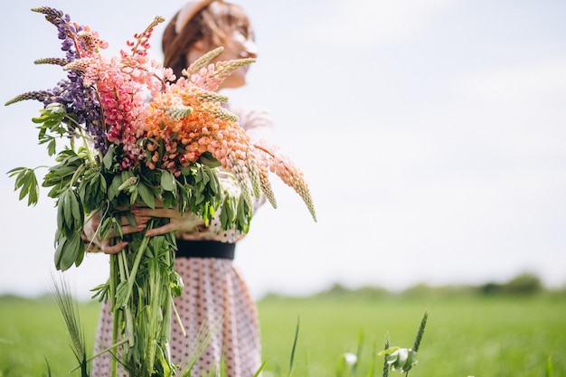 Woman walking in a field with lupinuses