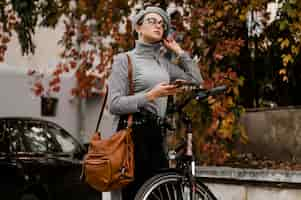 Free photo woman walking next to her bicycle