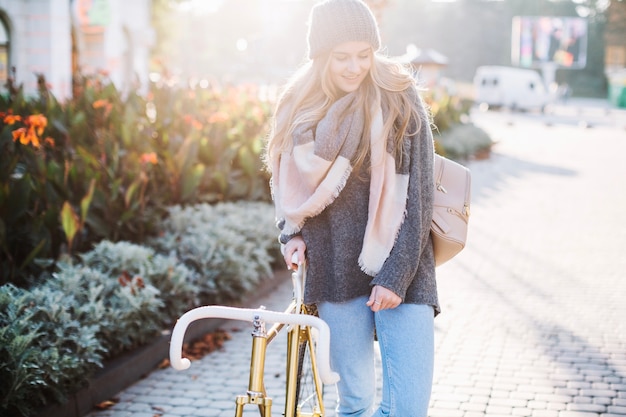 Free Photo woman walking near bicycle in park