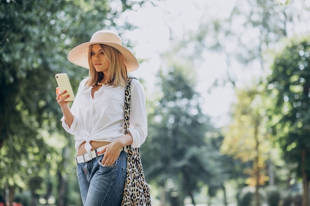 Woman walking in park and talking on the phone