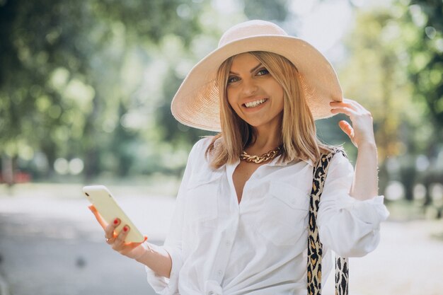 Woman walking in park and talking on the phone