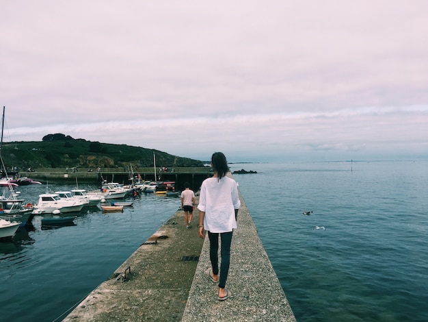 Woman walking on a pathway in the middle of the sea