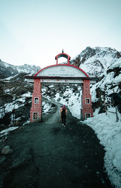 woman walking through brick gate in mountainous terrain