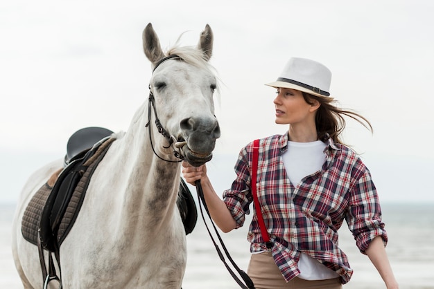 Free photo woman walking with a horse on the beach