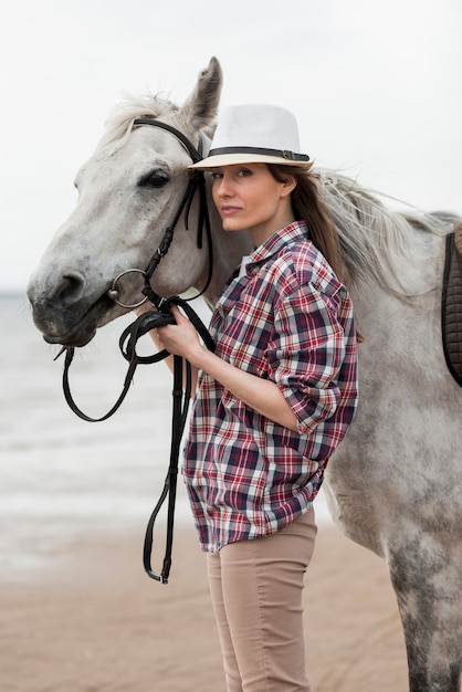 Free photo woman walking with a horse on the beach