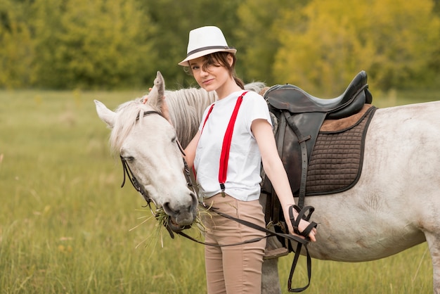 Woman walking with a horse in the countryside 