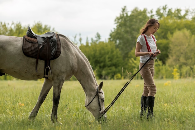 Woman walking with a horse in the countryside 