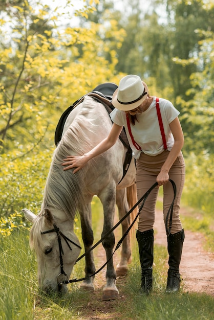 Woman walking with a horse in the countryside 