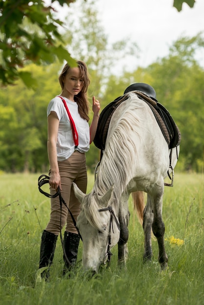 Free photo woman walking with a horse in the countryside