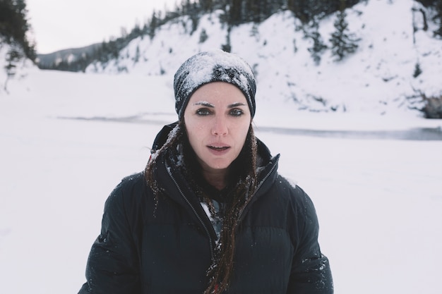 Woman in warm clothes on snowy background