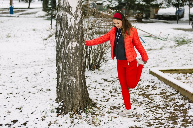 Woman warming up near tree