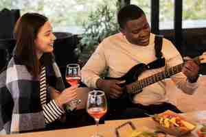 Free photo woman watching a man playing guitar at a party