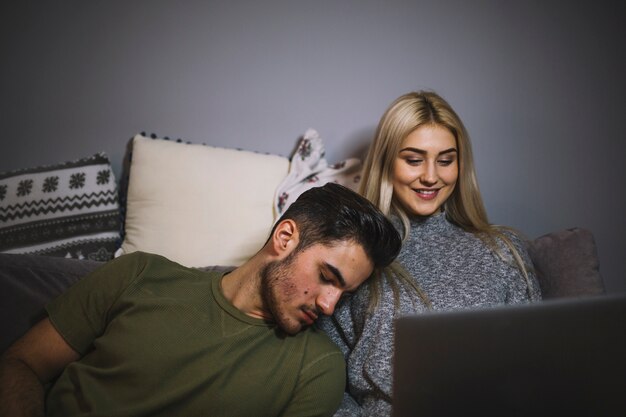 Woman watching movie near sleeping man