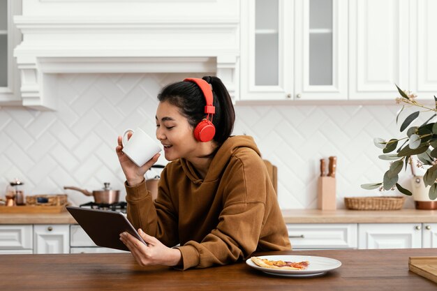 Woman watching a video on tablet and drinking coffee