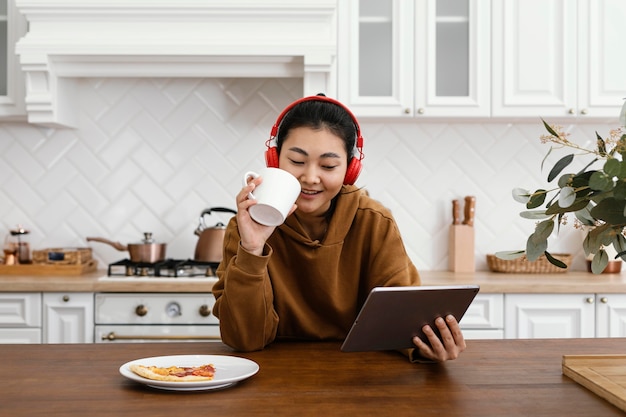 Woman watching a video on tablet and drinking coffee