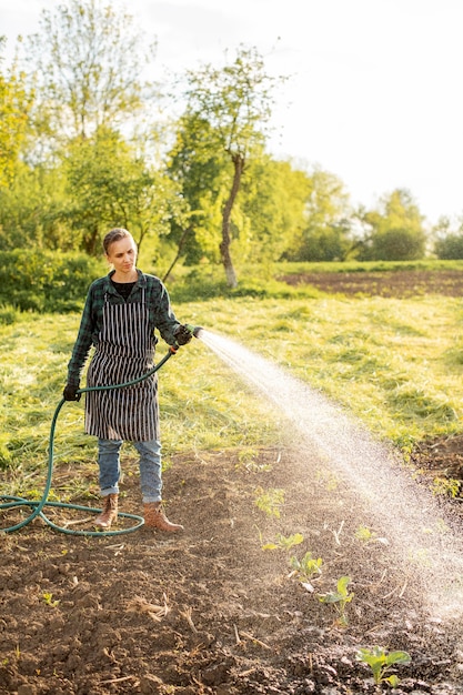 Free photo woman watering the crops