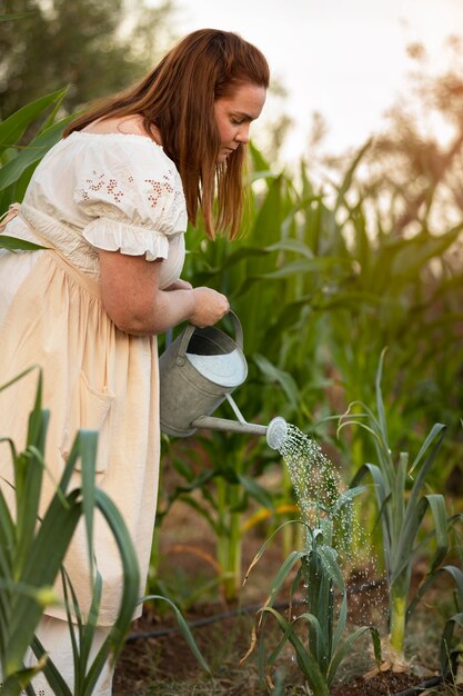 Woman watering plants side view