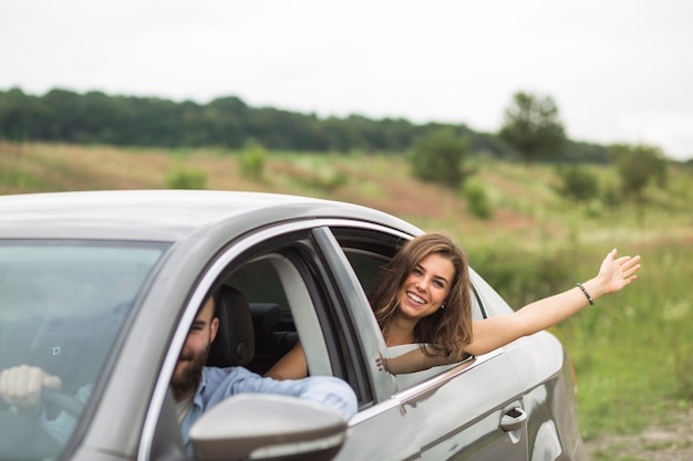 Woman waving her hand outside the car window