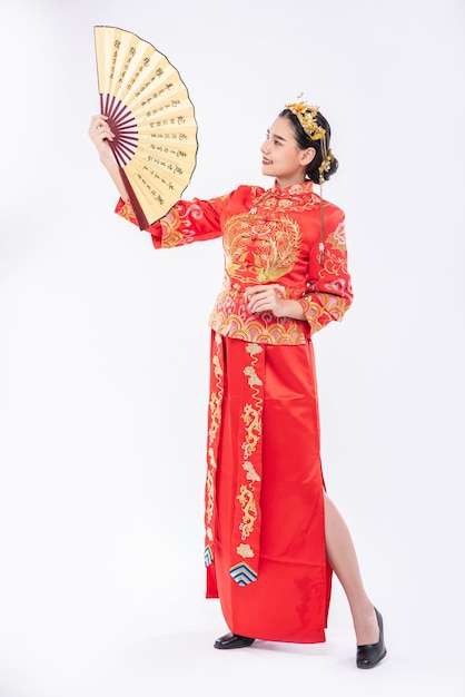 Free Photo woman wear cheongsam suit show the chinese hand fan on big event in chinese new year