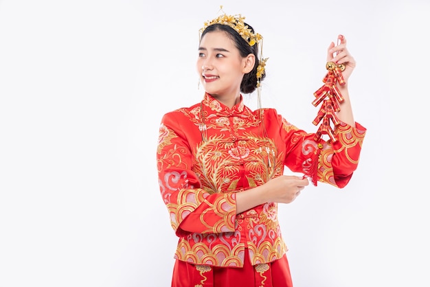 Free Photo woman wear cheongsam suit show the firecrackers to client for selling in chinese new year