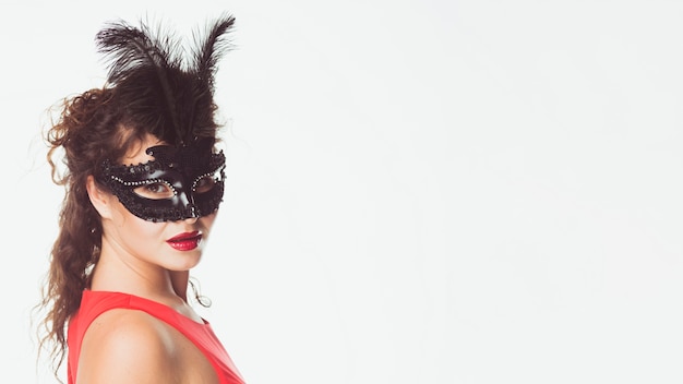 Free Photo woman wearing black mask with feathers