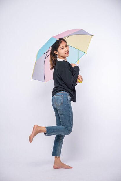 A woman wearing a black shirt and standing with an umbrella