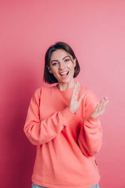 Woman wearing casual sweater on background clapping and applauding happy and joyful, smiling proud hands together