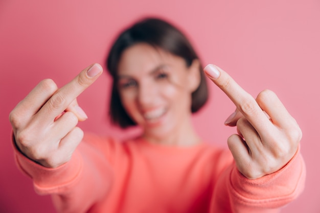 Free photo woman wearing casual sweater on background showing middle finger doing bad expression, provocation and rude attitude