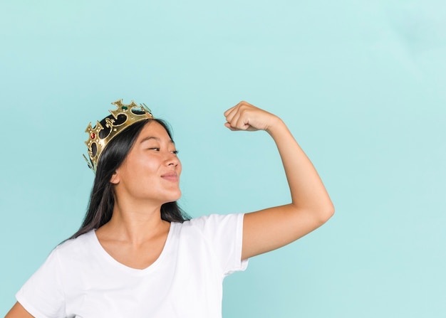 Woman wearing a crown and raising her arm