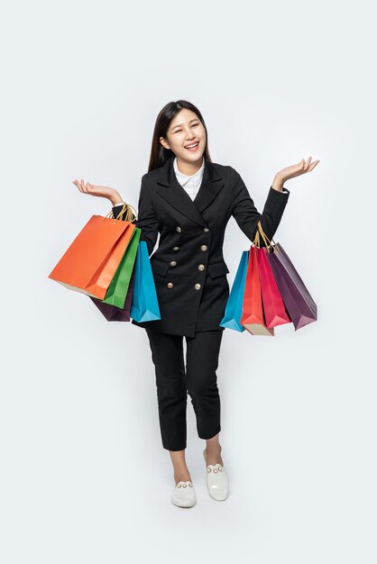 The woman wearing dark clothing, along with many bags, to go shopping