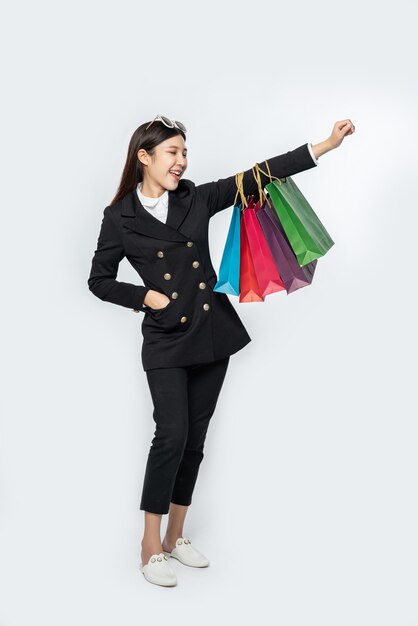 The woman wearing dark clothing, along with many bags, to go shopping