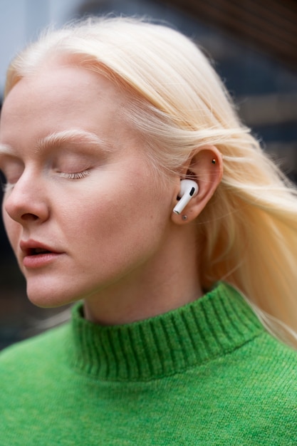 Free photo woman wearing earphones side view