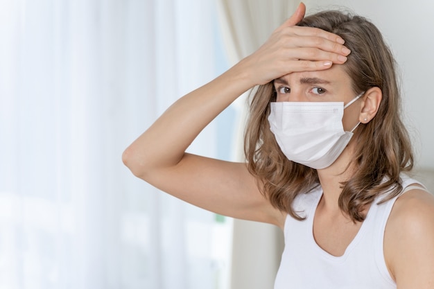 Free Photo woman wearing face mask to protect  feeling sick headache and cough because of coronavirus covid-19 in quarantine room