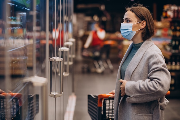 Woman wearing face mask and shopping in grocery store