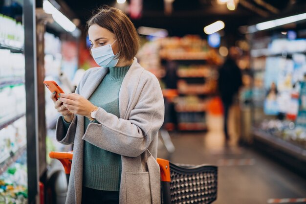 Woman wearing face mask and shopping in grocery store