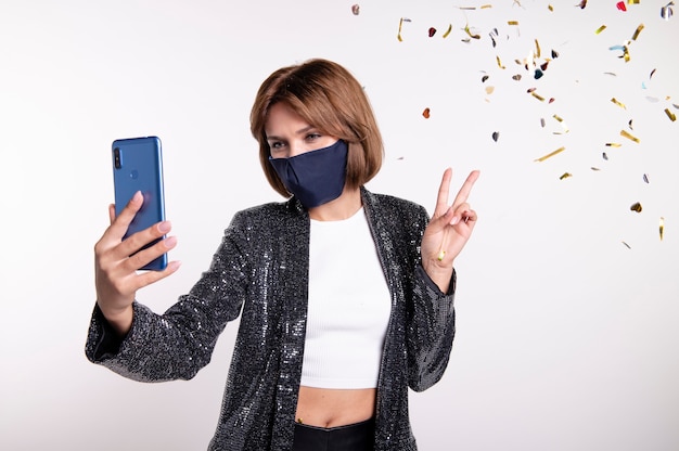 Woman wearing face mask taking a selfie