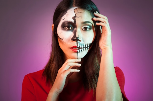 Woman wearing halloween mask and touching her head