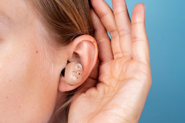 Free photo woman wearing hearing aids side view