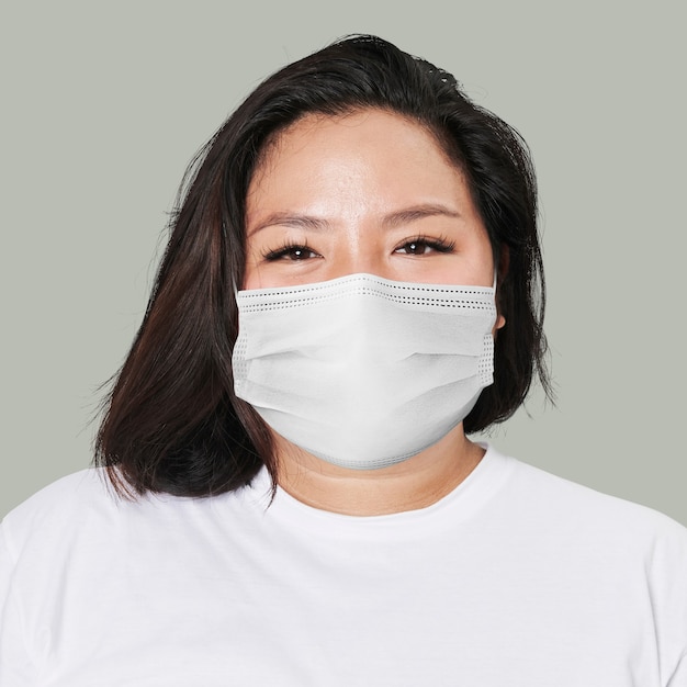 Woman wearing mask face closeup Covid-19 on green background