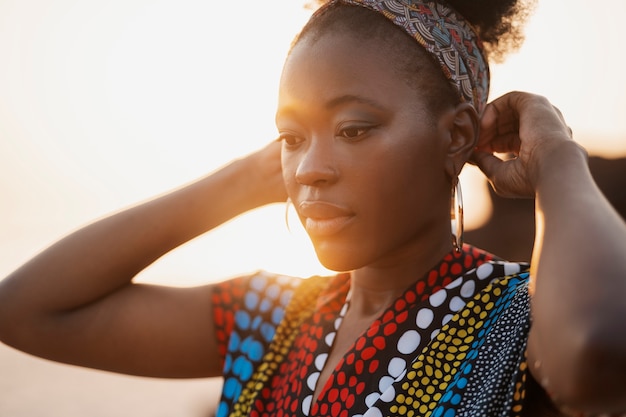 Free photo woman wearing native african clothing at sunset on beach