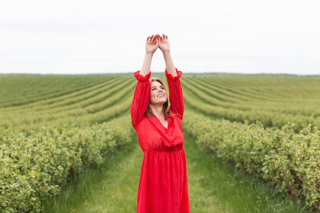 Woman wearing red dress in field