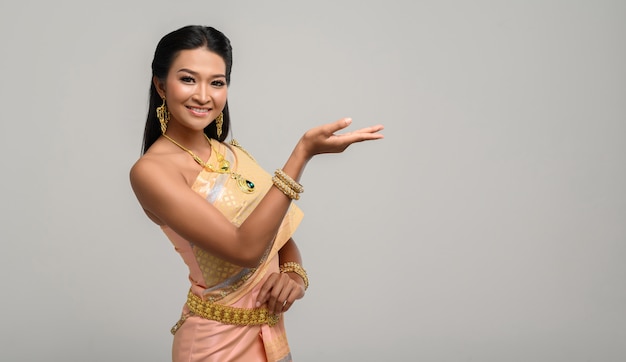 Free photo woman wearing thai dress that made a hand symbol