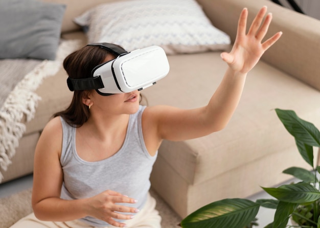 Free photo woman wearing vr glasses at home