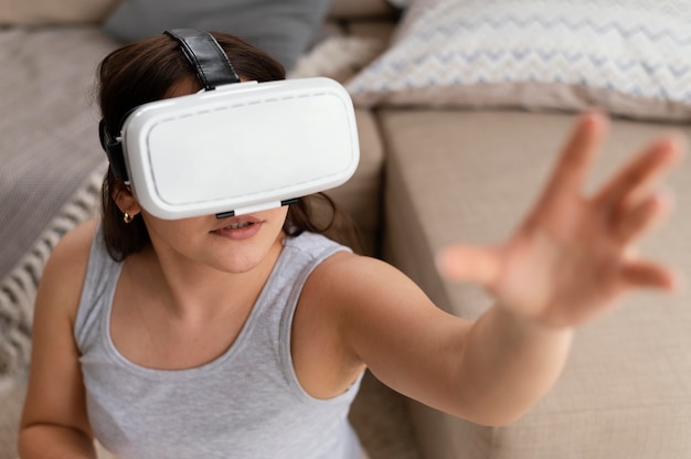 Free photo woman wearing vr glasses in living room